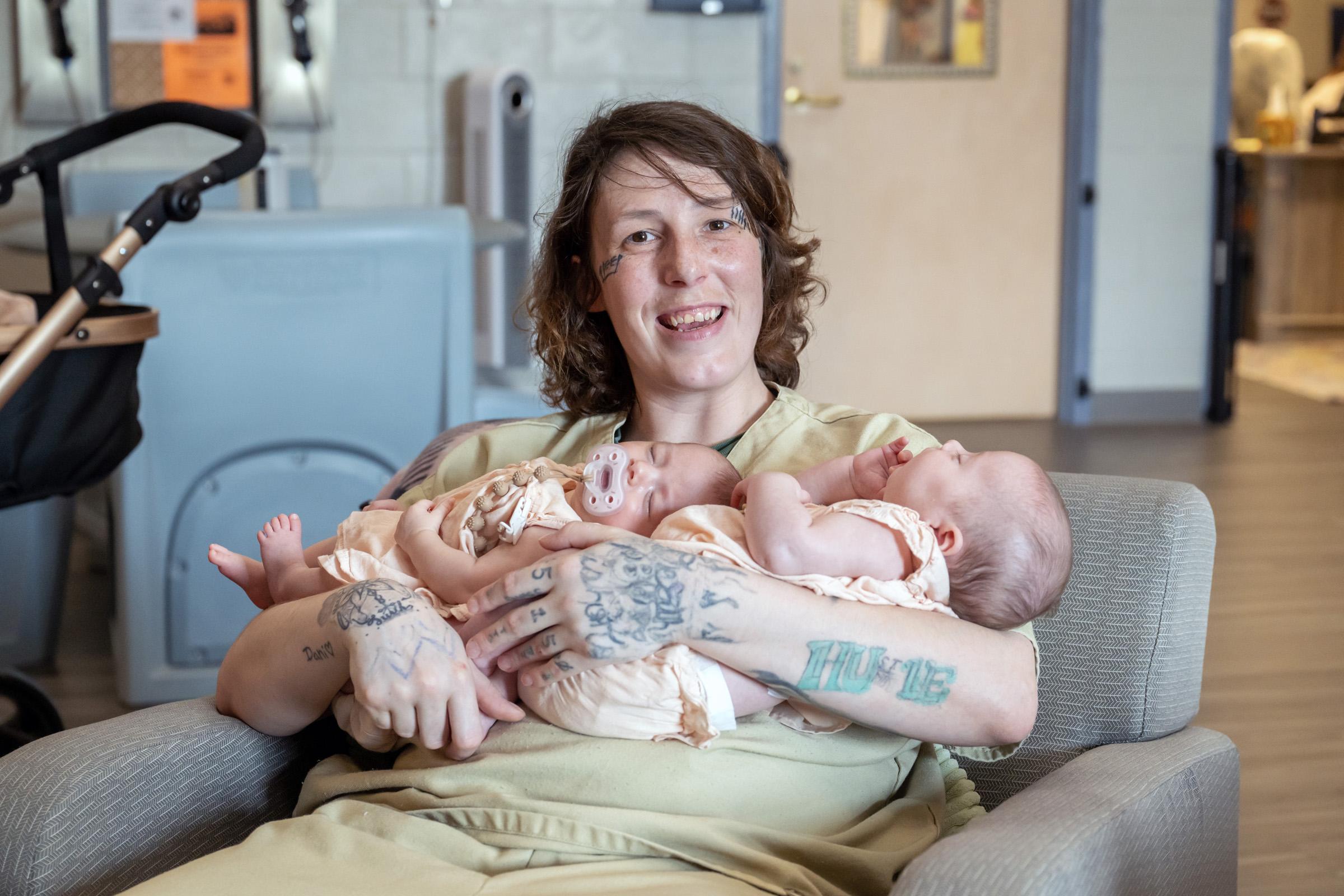A Prison Nursery Program mom holds twin babies.